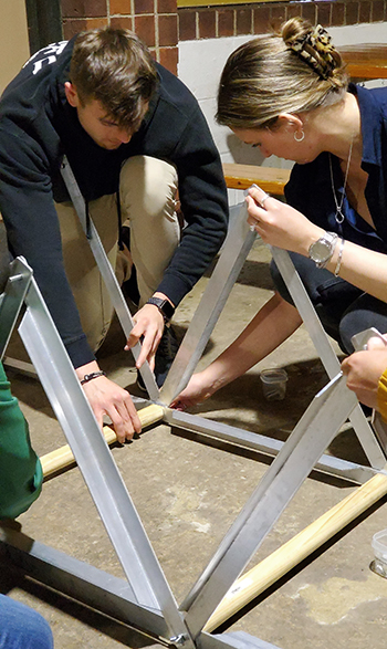 Photo: Two Graduate Trainees work on the Bridge-in-a-Bag activity. 